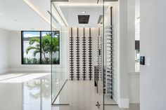 an empty hallway with wine racks on the wall and glass doors leading to another room