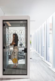 a woman standing in front of a glass display case with numbers on the wall and circles around her