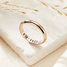 a close up of a ring on a white surface with dried grass in the background