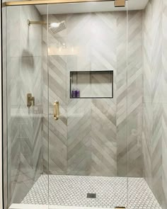 a walk in shower sitting next to a white tiled wall and wooden framed mirror above it