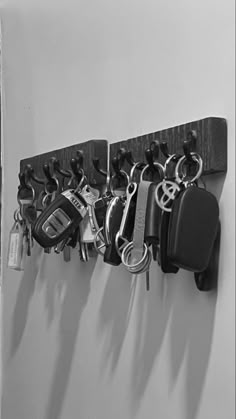 a bunch of keys are hanging on a wall with hooks and key chains attached to it