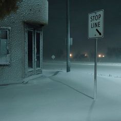 a stop sign on a pole in the middle of a snow covered field at night