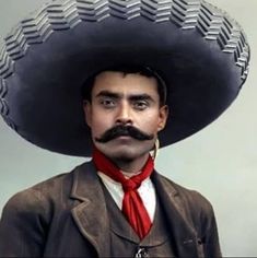 a man wearing a sombrero and a red tie with a moustache on his head