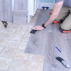 a man is laying tile on the floor