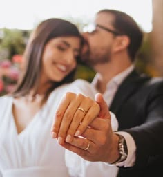 a man and woman are holding hands in front of each other while they pose for the camera