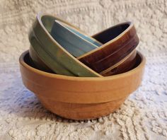 a wooden bowl filled with assorted bowls on top of a white cloth covered table