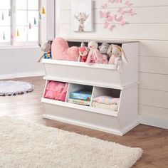 a white shelf filled with stuffed animals on top of a wooden floor