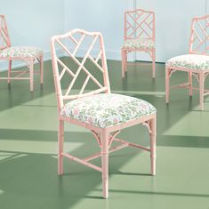 four pink chairs with floral upholstered seat covers in a green floored room