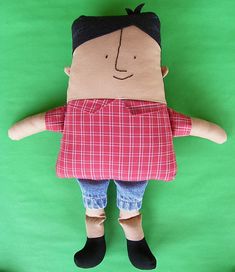 a stuffed doll is posed on a green background