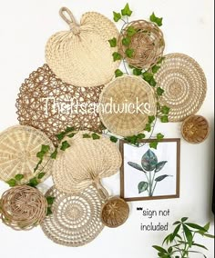 wicker baskets are arranged on the wall above a potted plant and framed photograph