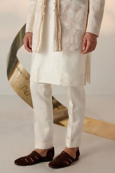 Ivory full sleeves bandhgala with all over abstract embroidery with tone on tone, champagne, old rose, and gold threads. Paired with matching slim fit tapered trouser.
Components: 2
Pattern: Embroidery
Type Of Work: Ditsy Floral
Neckline: Band
Sleeve Type: Long
Fabric: Linen Silk
Color: Ivory
Other Details: 
Twisted borders at the front
Note: The inner kurta worn by the model is not for sale
Occasion: Cocktail and Reception, Wedding - Aza Fashions Luxury White Bandhgala With Gota Work, Luxury Beige Chikankari Embroidered Bandhgala, Off White Bandhgala With Naqshi For Festive Occasions, Off White Naqshi Bandhgala For Festive Occasions, Designer Off-white Bandhgala For Eid, Festive Off White Bandhgala With Naqshi, Off White Bandhgala With Naqshi For Diwali, Fitted Off White Kurta With Naqshi, Off White Naqshi Bandhgala For Diwali