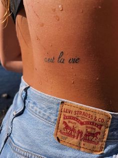 the back of a woman's stomach with words written on it and small patches in between her thighs