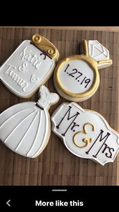 three decorated cookies with the names and date on them are sitting on a wooden table