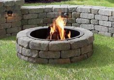 an outdoor fire pit sitting in the grass