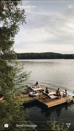 some people are sitting on a dock by the water