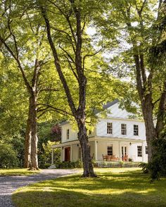 a white house surrounded by trees and grass