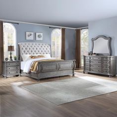 a bedroom scene with focus on the bed, dressers and mirror in the room