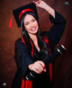 a woman wearing a graduation gown and holding a wand in her hand with both hands