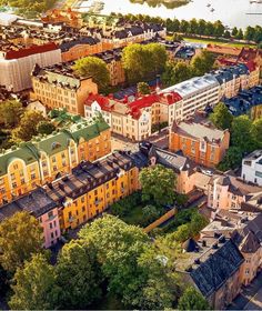 an aerial view of a city with lots of buildings and trees in the foreground