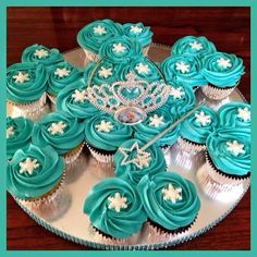 cupcakes with blue frosting and white icing are arranged on a tray