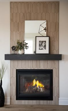 a fire place in a living room with pictures on the wall