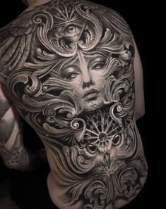 a man's back with an intricate tattoo design on his arm and shoulder, which has