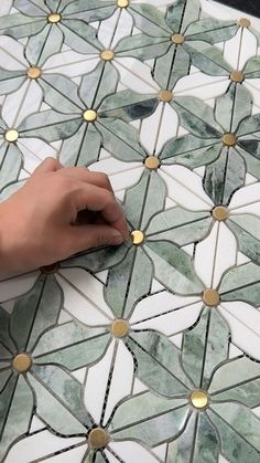 a person is working on a mosaic tile design