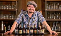 a man sitting at a bar with several beer bottles in front of him on the counter