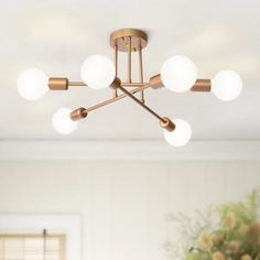 a chandelier hanging from the ceiling in a room with white walls and windows