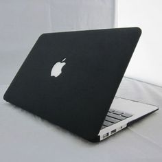 an apple laptop computer sitting on top of a white tablecloth covered table with a black cover