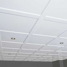 an empty room with white ceiling tiles and lights