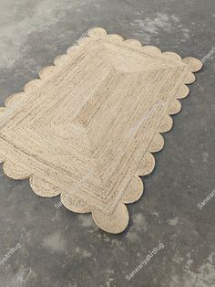 a beige rug with scalloped edges on the floor