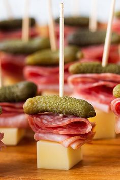 mini sandwiches with pickles and cheese on them are ready to be served at a party