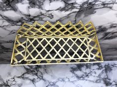 a gold metal tray sitting on top of a marble counter next to a black and white wall