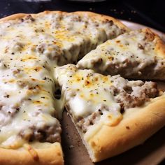 a pizza with cheese and meat toppings sitting on a wooden platter, ready to be eaten