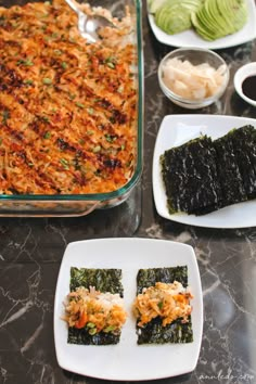 an assortment of sushi on plates with dipping sauce