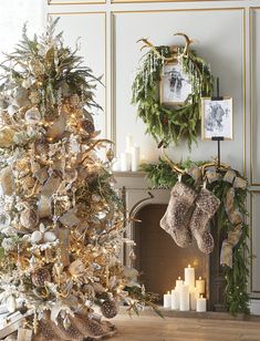 a decorated christmas tree with stockings hanging from it's sides in front of a fireplace