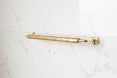 a gold handle on a white marble wall