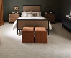 a bedroom with a bed, dresser and foot stools