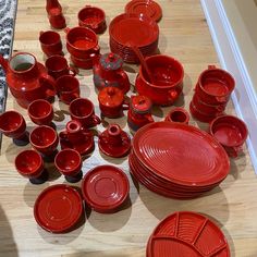 many red dishes and cups on a wooden table