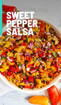 a white bowl filled with chopped bell peppers and carrots on top of a table