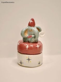 an elephant figurine sitting on top of a red and white box with stars