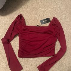 The Sleeves Are Mesh Fitted Burgundy Tops For Night Out, Burgundy Tops For Fall Party, Burgundy Top For Fall Party, Fall Party Burgundy Top, Stretch Burgundy Tops For Night Out, Burgundy Stretch Top For Night Out, Trendy Stretch Red Blouse, Chic Red Fitted Top, Burgundy Tops For Date Night In Fall