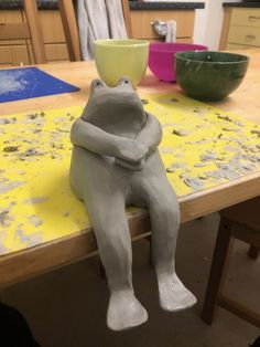 a ceramic bear sitting on top of a wooden table