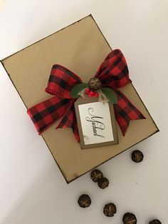 a brown box with a red and black bow on top of it next to nuts