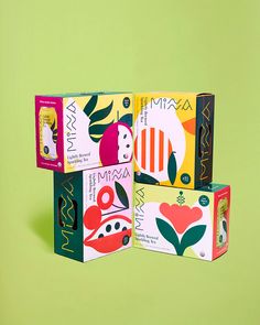 three boxes with different designs on them sitting next to each other in front of a green background