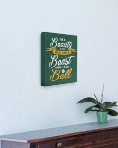 a wooden dresser with a potted plant on it and a green wall hanging above it