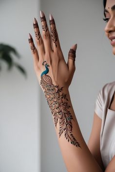 a woman with henna tattoos on her arm and hand is holding out her hands