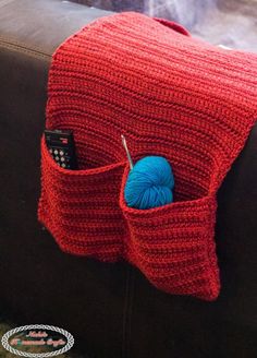 a crocheted red bag with a blue ball of yarn in it and the text, how to crochet a armchair caddy