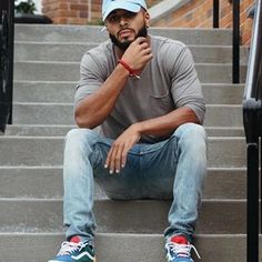 a man sitting on the steps with his hand under his chin